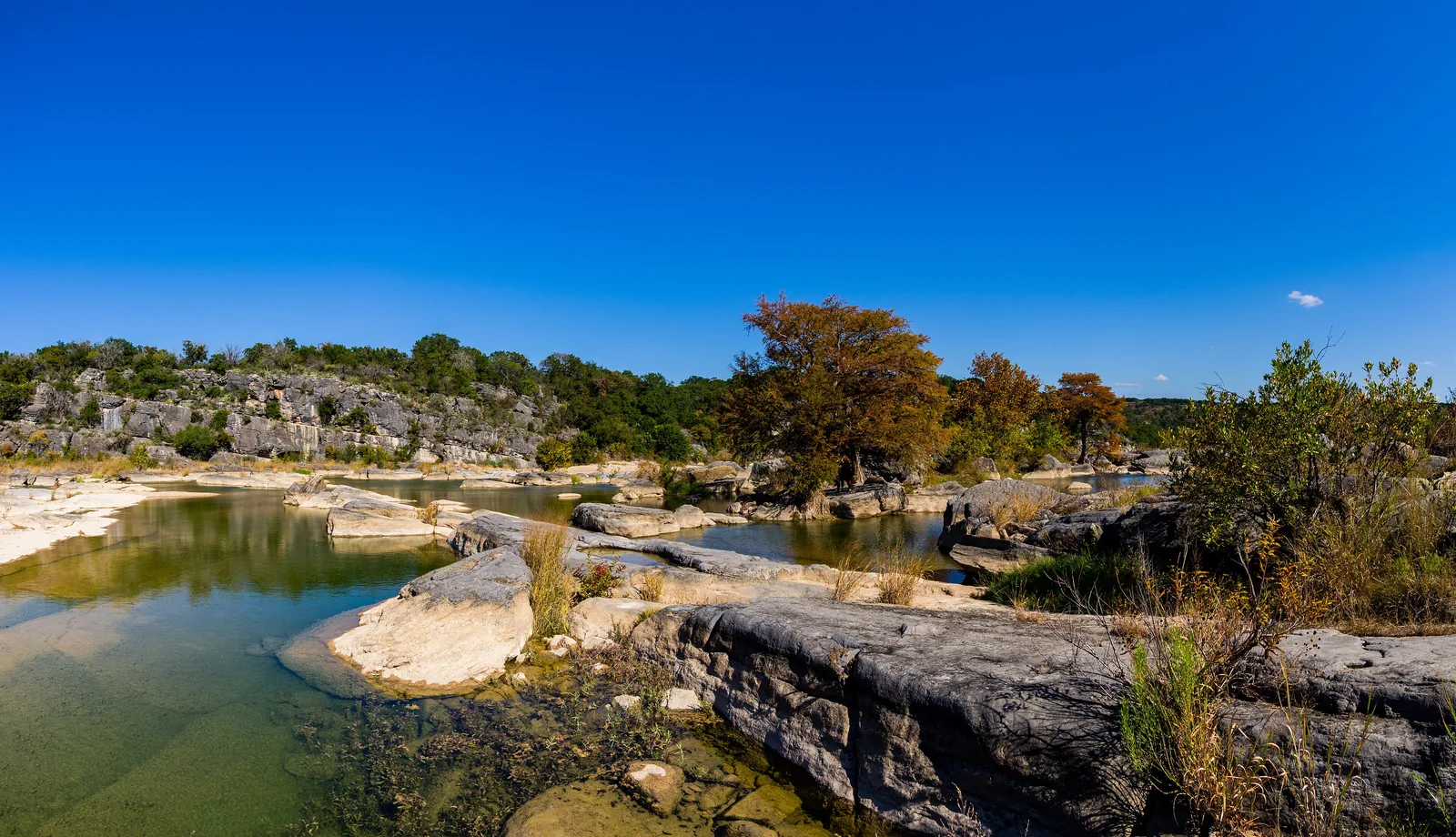 Pedernales River pools and limestone under a bright blue sky, Pedernales Falls State Park, Texas Hill Country