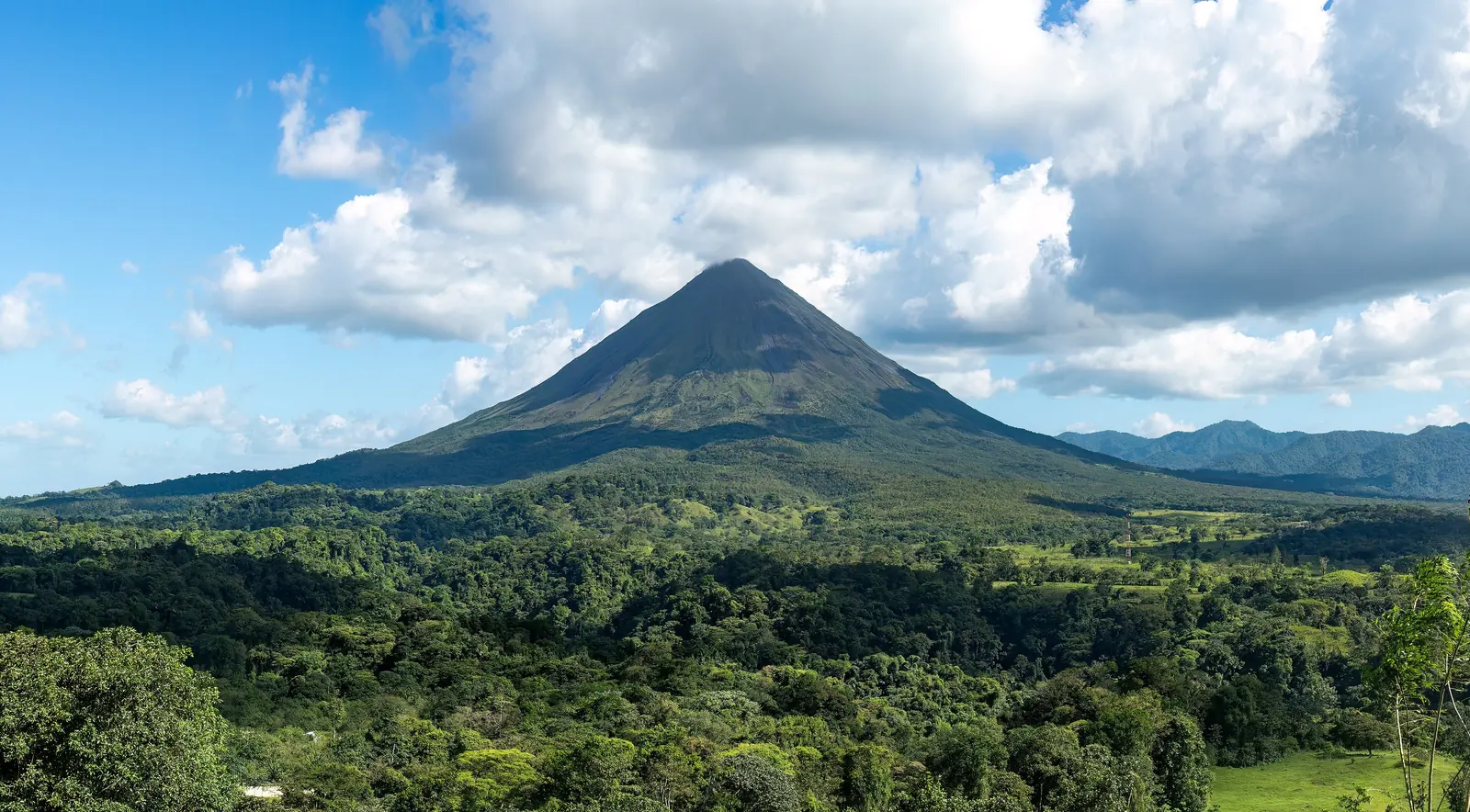 Arenal Volcano rising above green rainforest in Costa Rica