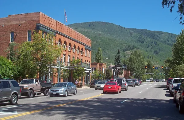 Main Street in Aspen with brick buildings and mountains behind