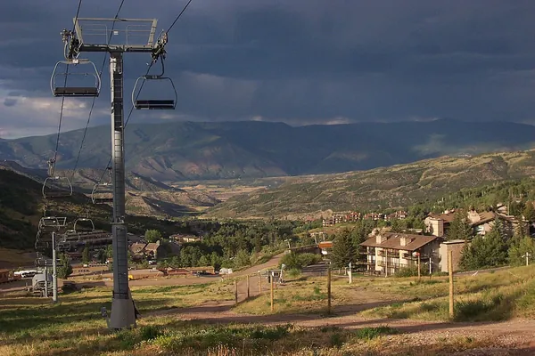 Green summer slopes and a chairlift in Snowmass Village