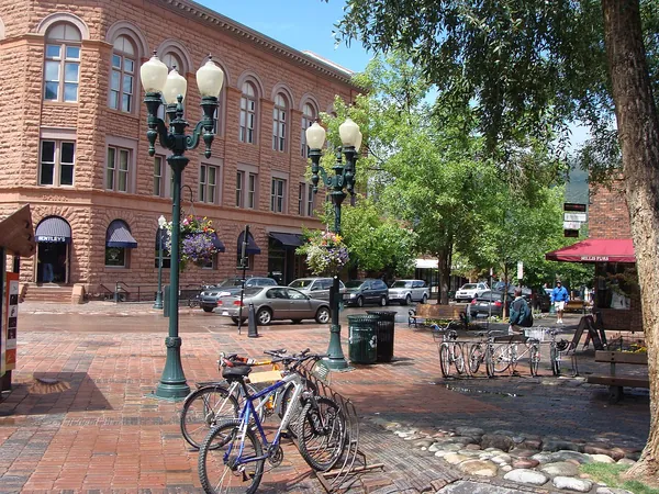 A sunny street in downtown Aspen with mountains behind