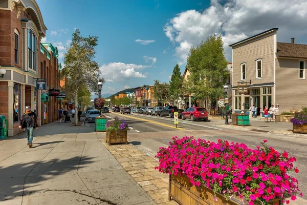 Sunny summer day on Main Street in Breckenridge, with bright pink flower planters and historic storefronts
