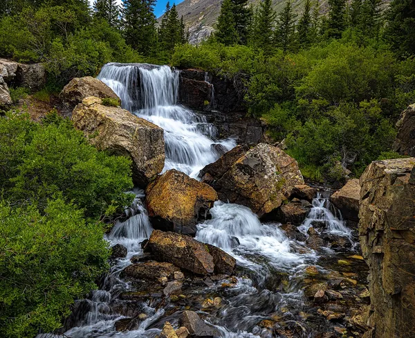 Monte Cristo Gulch Falls tumbling over rocks among green trees near Breckenridge