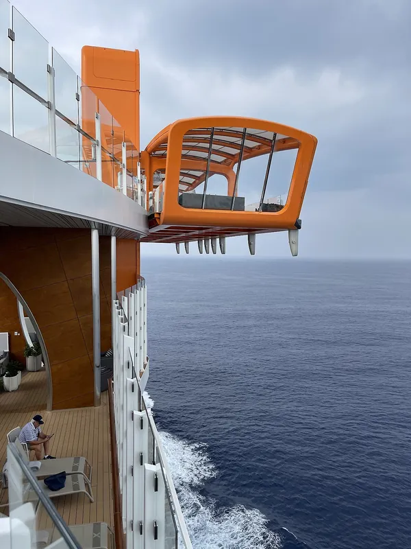 The orange Magic Carpet platform cantilevered off the side of Celebrity Apex at deck 16