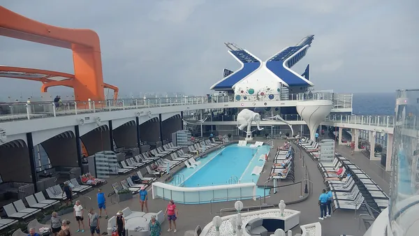 The Resort Deck pool and loungers on Celebrity Beyond with the X funnel behind