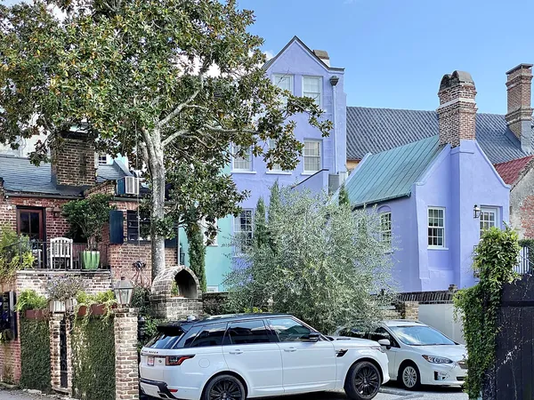 Lavender and blue historic homes behind trees on East Bay Street, Charleston