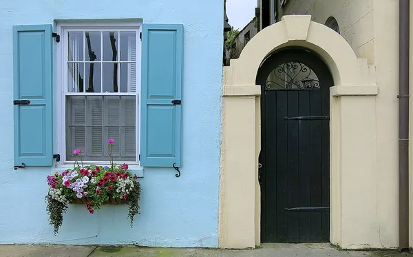 Pastel blue house front with shutters and a flower box on Rainbow Row