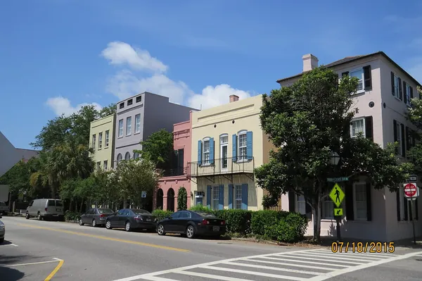A row of colorful historic houses under a blue sky in Charleston