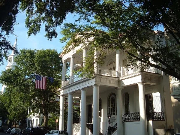 A white historic home with columns and a porch in downtown Charleston