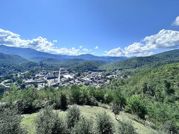 Green forested mountains above Gatlinburg under a blue sky with white clouds