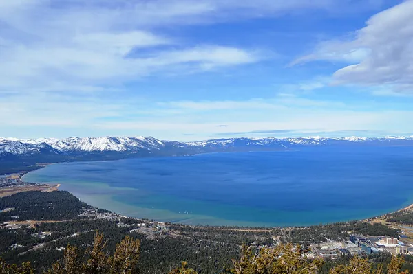 Wide view of South Lake Tahoe and snow-capped mountains from Heavenly