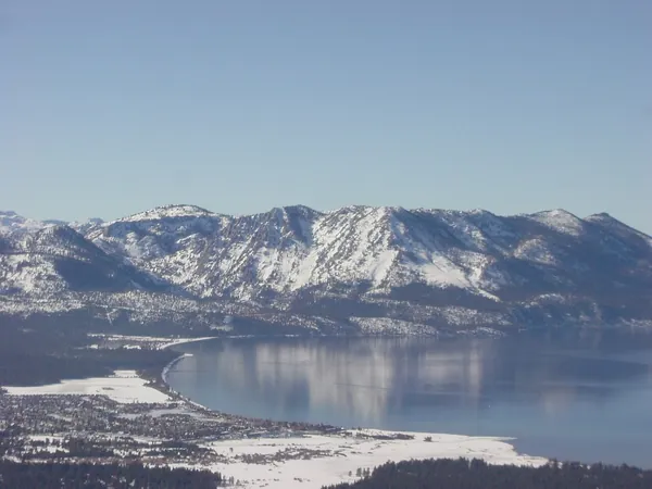 Snowy mountains reflected in calm Lake Tahoe