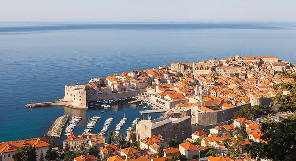 Red-tiled roofs and walls of Dubrovnik’s old town above the blue Adriatic, Croatia
