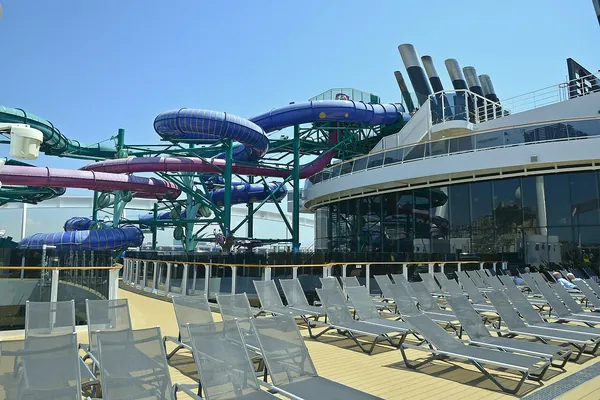Purple and green waterslides above the pool deck of MSC World Europa