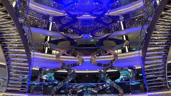Blue-lit staircases and balconies around the atrium of MSC Virtuosa