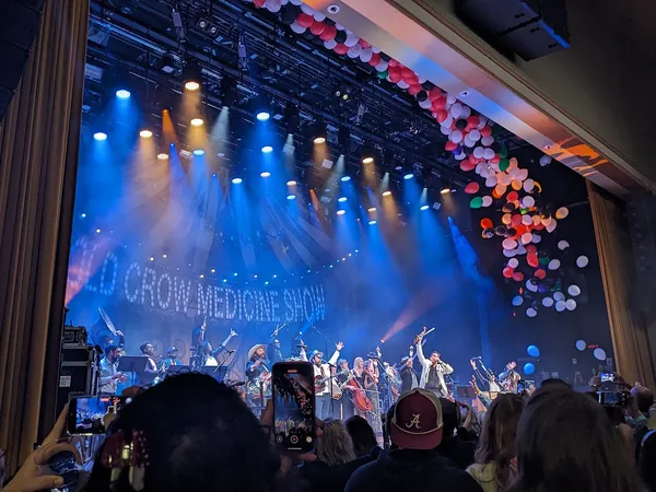 A colorful stage and crowd during a concert at the Ryman Auditorium