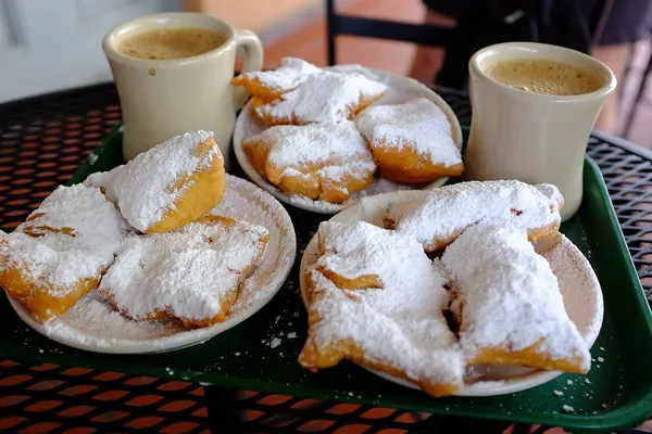 Plates of beignets with powdered sugar and café au lait at Café du Monde