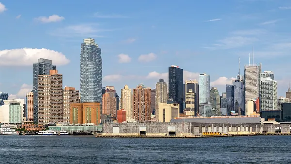 Lower Manhattan skyscrapers along the water on a sunny day