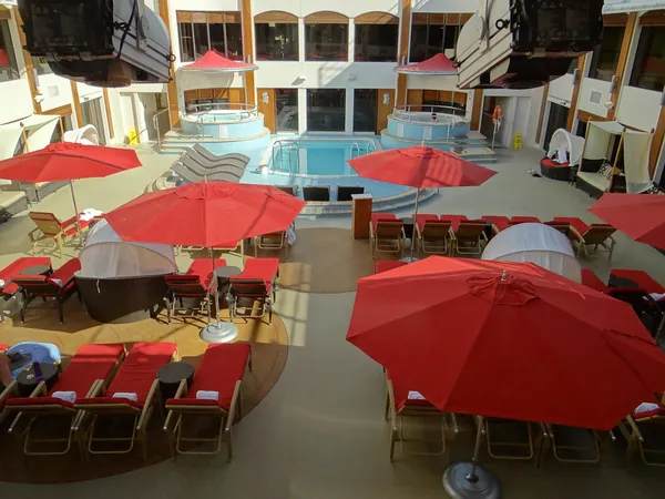 Red umbrellas and loungers in The Haven courtyard, the private ship-within-a-ship on Norwegian Epic