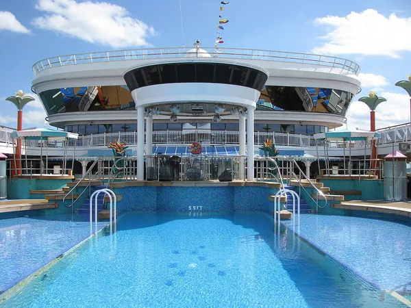 The main pool and sun deck of Norwegian Dawn under a blue sky