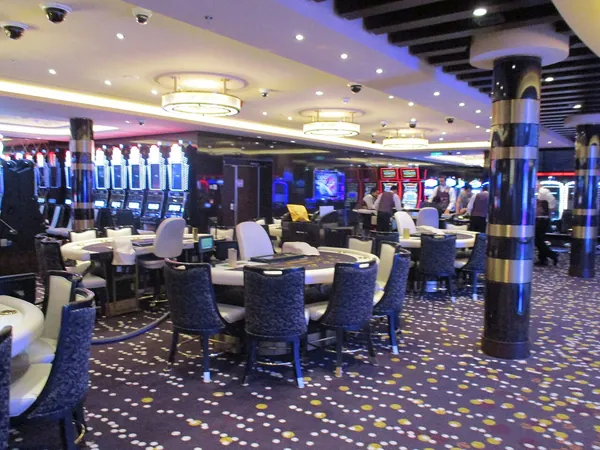 Gaming tables and bright lights in the casino on Norwegian Bliss