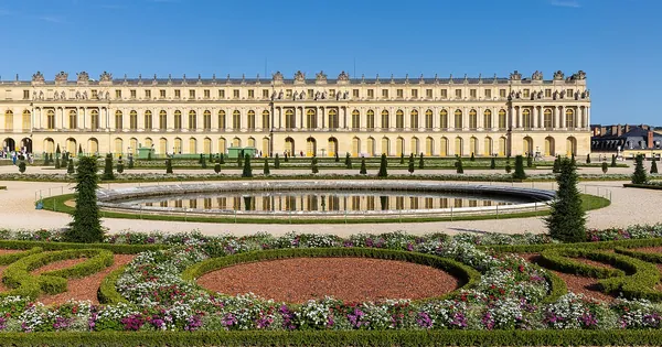 Garden ponds and facade of the Palace of Versailles at golden hour