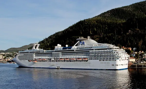 Coral Princess docked in Ketchikan, Alaska, below green forested mountains