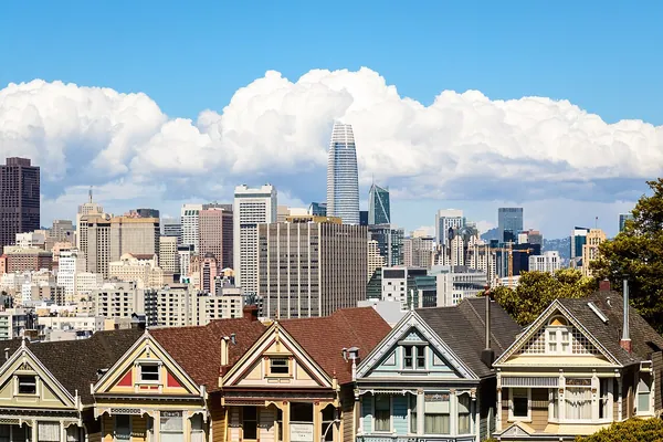Victorian houses at Alamo Square with the downtown San Francisco skyline behind