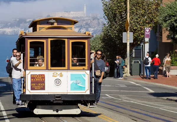 A San Francisco cable car on the street with riders aboard