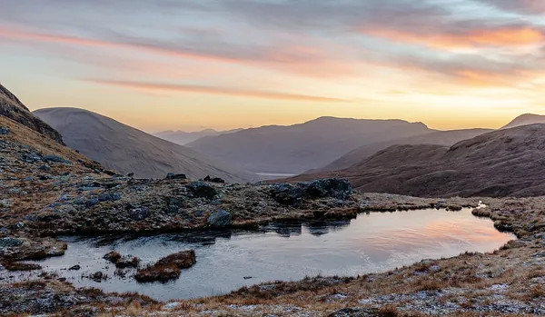 A small highland loch surrounded by mountains in Scotland
