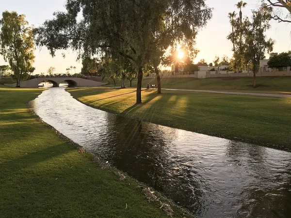Sunlight over a green park and stream in Scottsdale