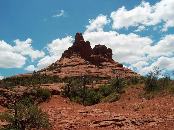 Bell Rock under a blue sky with white clouds in Sedona
