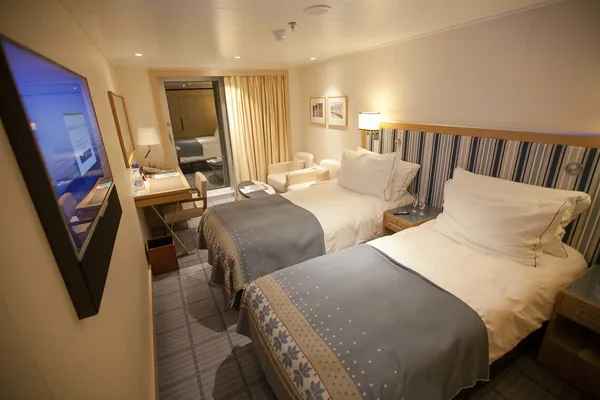 A veranda stateroom on Viking Star with its bed, sofa and glass door to the balcony