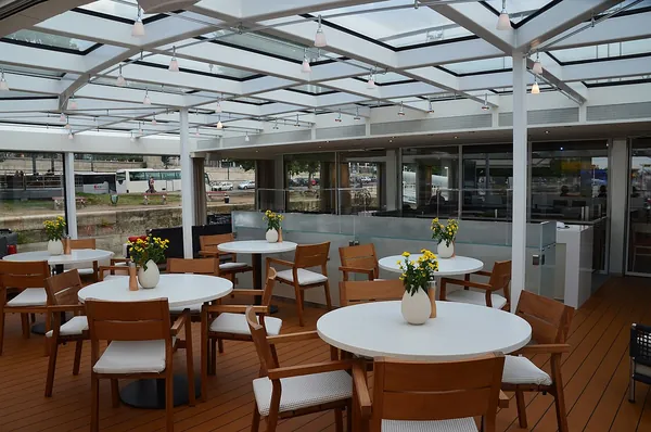 Tables on the glass-sided Aquavit Terrace at the bow of the river ship Viking Embla
