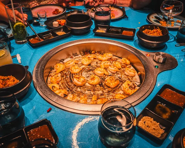 A Korean barbecue grill surrounded by small dishes at Gunbae on Valiant Lady
