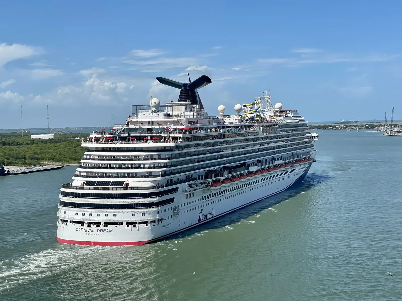 Carnival Dream cruise ship sailing past Galveston, Texas, under a blue sky