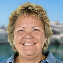Karen Murphy, owner of Infinity Premier Travel, smiling at a marina