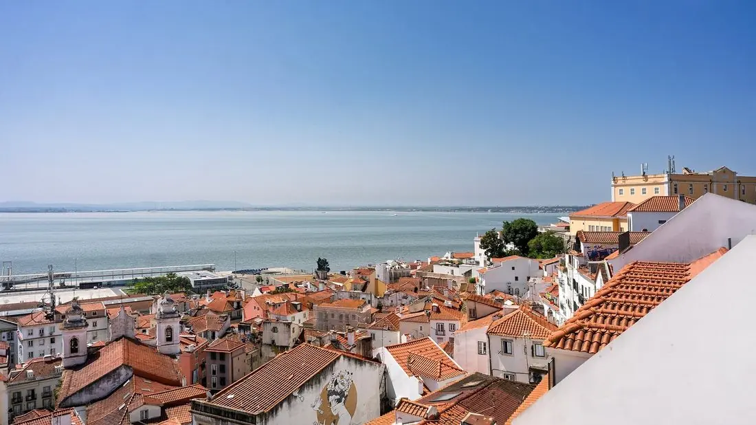 Red-tiled rooftops of Lisbon’s Alfama district above the Tagus River