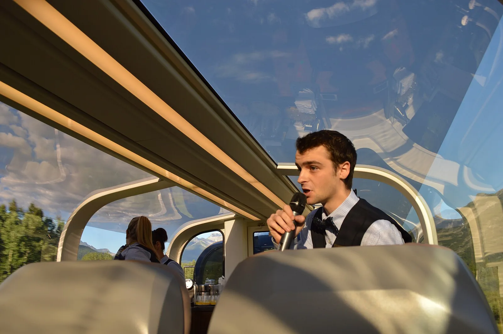 Sunlit glass-dome coach on Rocky Mountaineer with blue sky overhead