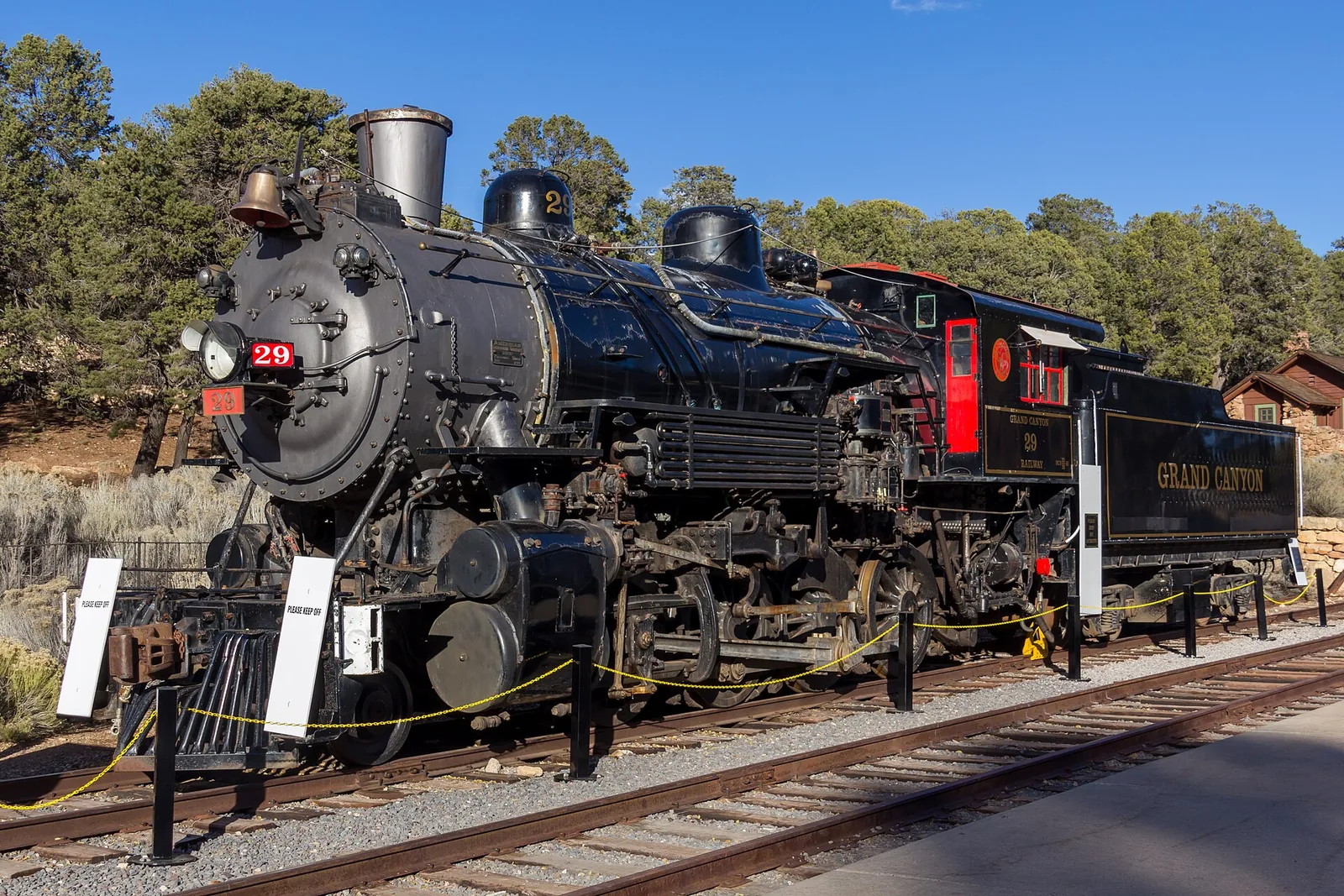 Grand Canyon Railway steam locomotive under a bright blue Arizona sky