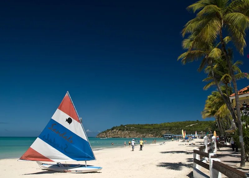 Sailboat on the white sand of Dickenson Bay, Antigua